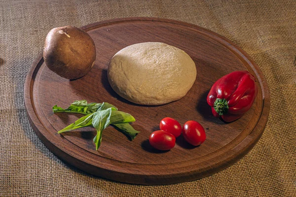 Préparation pâte à pizza italienne avec légumes sur la table. — Photo