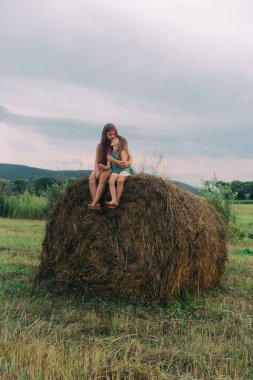 İki kız kardeş samanlıkta oturuyor.