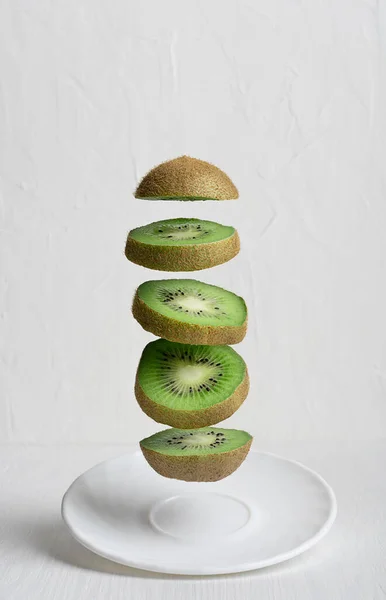 Flying Levitating Group Ripe Juicy Kiwi Fruit Slices Plate Wooden — Stock Photo, Image