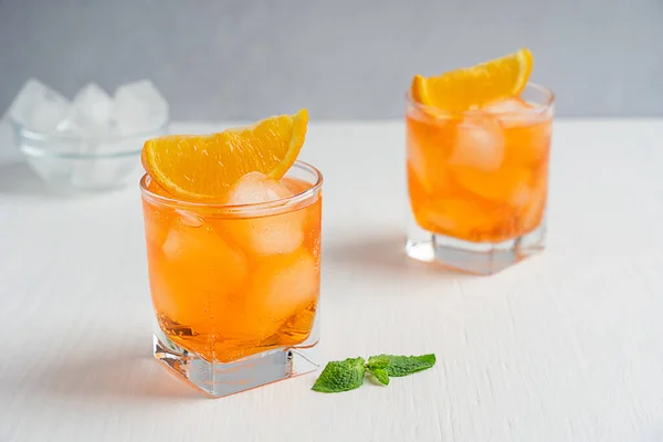 Friss Hideg Csillogó Narancssárga Lédús Ital Két Ivópohárban Citrusszelettel Mentalevéllel — Stock Fotó
