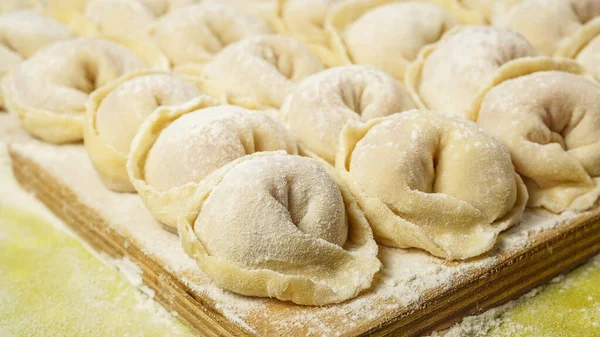 Kesme tahtasında Rus köftesi. Hamur köftelerini pişirme yöntemi. Etli Rus böreği. Ev yapımı ravioli. fotoğraf