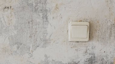 Beton duvarda eski bir elektrik düğmesi var.