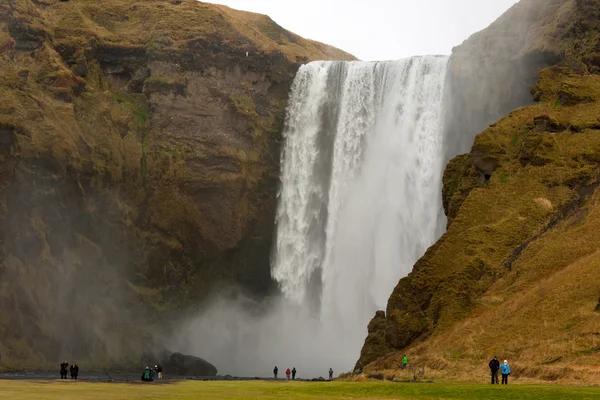 People at skogafoss cascade landscape Royalty Free Stock Images