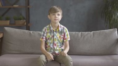 Evde hediye alan ve tutan tişörtlü çocuk portresi.