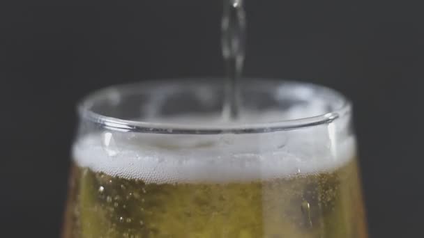 Light cold beer pouring into glass. Close up. Isolated on black background — Stock Video