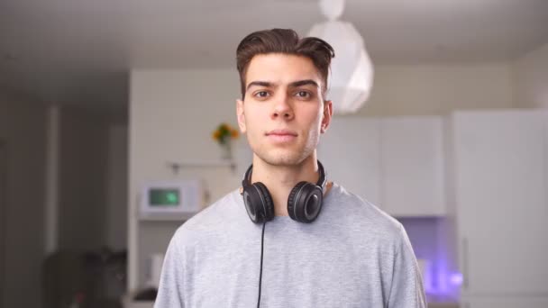 Portrait of smiling cool guy with headphones around the neck — Stock Video