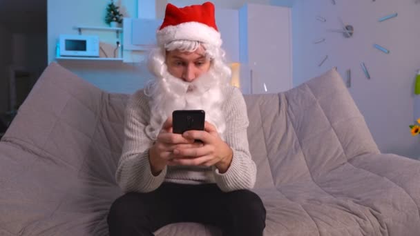 Noel Baba 'nın cep telefonu uygulamasını akıllı telefonda kullanmasına şaşırdım. Noel terfisi ve xmas uygulamaları yüzünden şok oldum. — Stok video