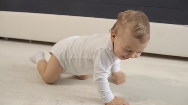 Lindo niño de nueve meses arrastrándose en un piso en casa, cámara lenta — Vídeos de Stock