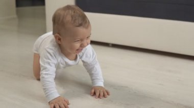 Bedeninin içinde sürünen komik bebek. Gülümsüyor, evde sürünüyor..