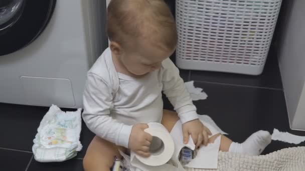 Дитяча рука хлопчика тримає рулон і розриває білий туалетний папір . — стокове відео