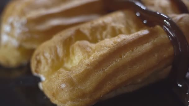 Menuang karamel saus manis pada eclair yang baru dipanggang — Stok Video