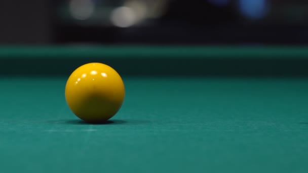 Närbild av en man träffar den gula bollen med en kö. Spela biljard på det gröna bordet. — Stockvideo