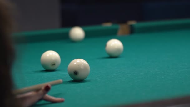 女のクローズアップがキューでボールを打ち、穴を叩く。緑のテーブルでビリヤードをプレイ. — ストック動画