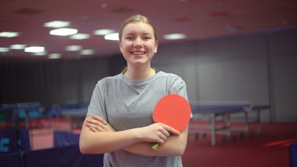 Portret van een lachend jong meisje tafeltennisser met een ping pong racket — Stockvideo
