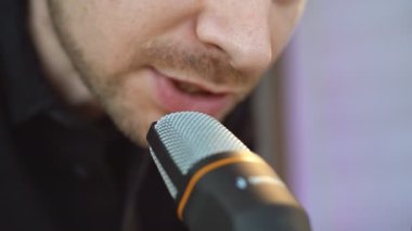 Moda podcast yapımcısı evinde ses yayını yapıyor. Mikrofon kullanarak bir röportaj yayınlanıyor