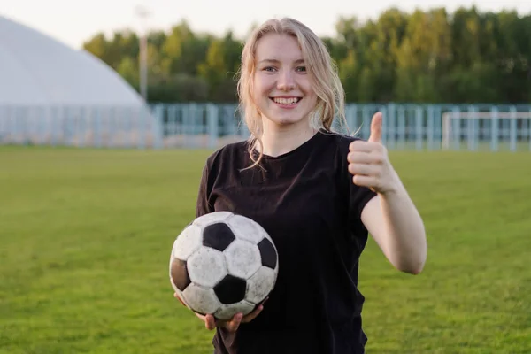 Mladý dospívající dívka fotbalista drží fotbalový míč s palcem nahoru — Stock fotografie
