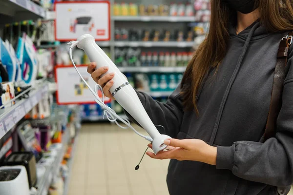 Клиентка выбирает новый ручной блендер в магазине бытовой техники — стоковое фото