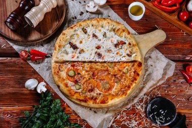 Mutfak masasında uzanmış pizza, malzemeler etrafa saçılmış..