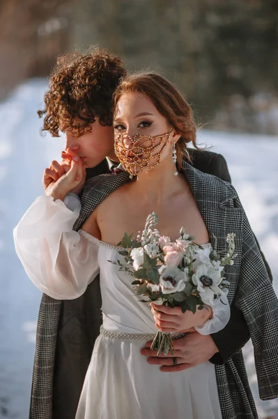 花嫁と新郎は雪に覆われた森の中に立っている — ストック写真