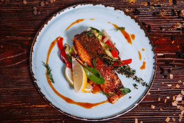 Soslu kızarmış balık ve sebze. Masanın üzerinde.