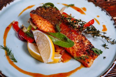 Soslu kızarmış balık ve sebze. Masanın üzerinde.