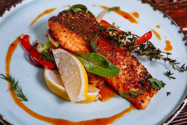 Soslu kızarmış balık ve sebze. Masanın üzerinde.