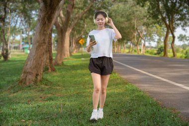 Kadın, kulaklık ve telefon. Sabah sabah koşmak için. Sağlıklı ve aktif yaşam tarzı kavramı.