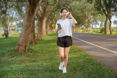 Kadın, kulaklık ve telefon. Sabah sabah koşmak için. Sağlıklı ve aktif yaşam tarzı kavramı.
