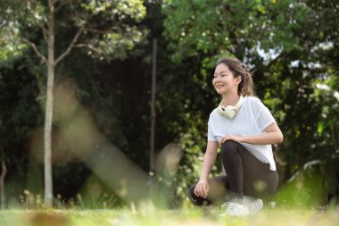 Eğitimden önce spor yapmadan ya da antrenman yapmadan önce esneme hareketleri yapan genç Asyalı kadın sağlıklı bir yaşam tarzının keyfini çıkarıyor..