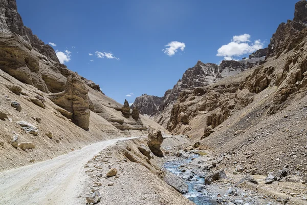 Estrada da montanha nas proximidades rio em montanhas rochosas irregulares — Fotografia de Stock