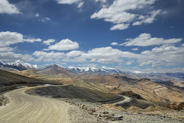 Vista del camino curvo entre montañas cubiertas de nieve — Foto de Stock