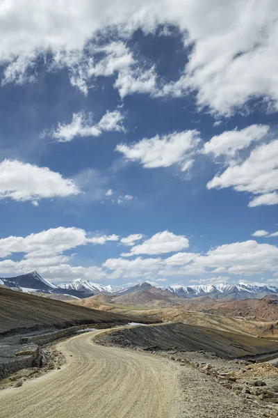 Vue de la route courbée parmi les montagnes enneigées — Photo