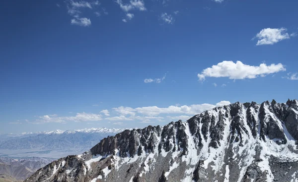 Sharp snow covered mountain ridge with high mountain range background — Stock Photo, Image