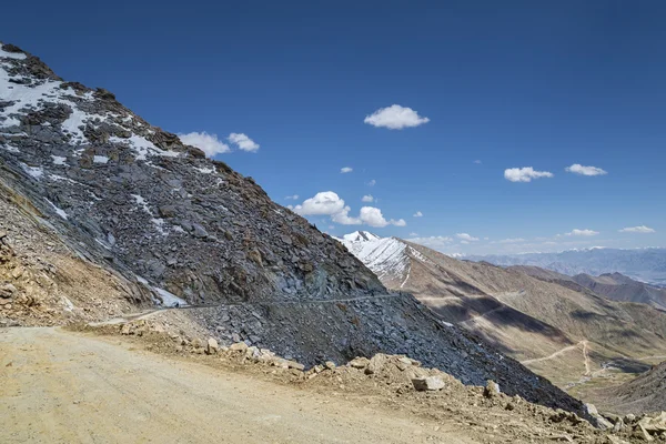 Pohled na klikaté silničce hadec s pozadí pohoří — Stock fotografie