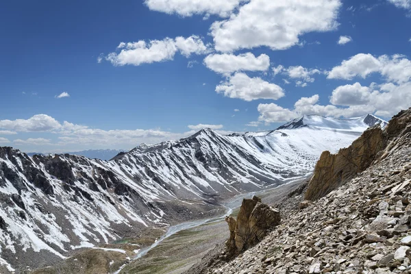 Nieve aguda cubierta de cresta de montaña con río y valle verde en el fondo — Foto de Stock