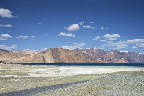 High mountain road beside of deep blue lake — Stock Photo, Image