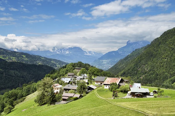 Scenic landschap met kleine alpine dorp op groene heuvel — Stockfoto