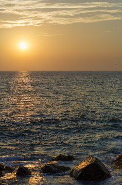 Kayalık okyanus kıyısı yansıyan gün batımında