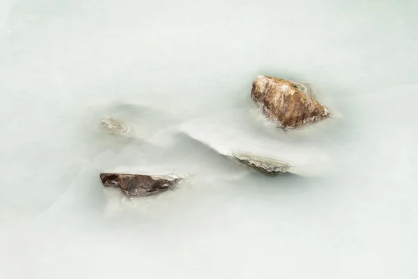 Stones in silty water — Stock Photo, Image