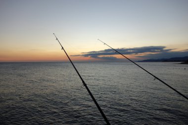 gün batımında balıkçılık çubuklar