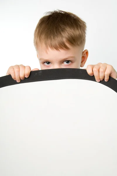 Little boy hiding his face behind the white deflector — Stock Photo, Image