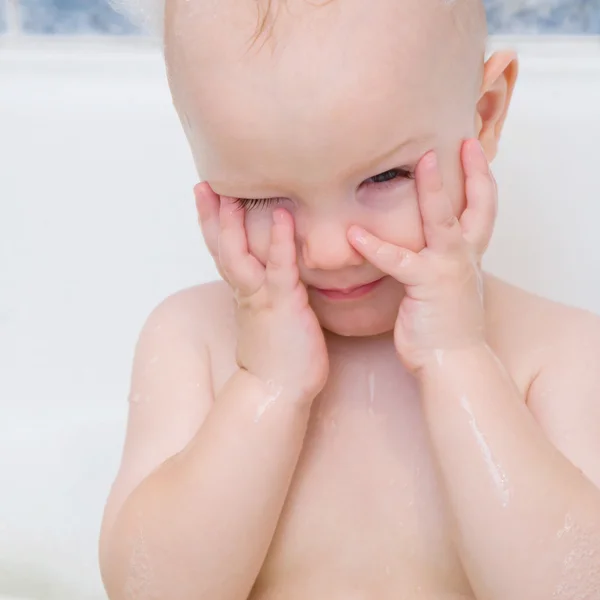 Pequeño niño tomando un baño con espuma de jabón cuidado del bebé momentos suaves —  Fotos de Stock