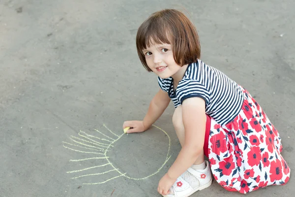 Little girl drawing on the asphalt close-up Royalty Free Stock Images