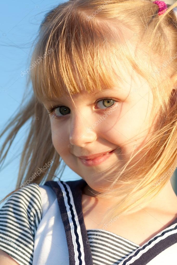 Klein meisje 7-10 jaar oud close-up portret buitenshuis bij de zonsondergan...