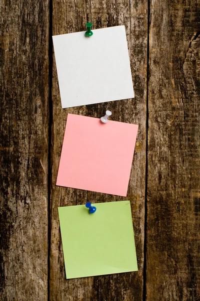 Aantekeningen op papier in de houten muur — Stockfoto