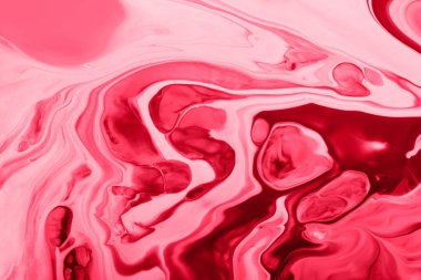 Tek renkli pembe mermer arka plan. Karışık tırnak cilası, makyaj konsepti. Güzel sıvı tırnak lekeleri. Sıvı sanat, dökme teknikleri..