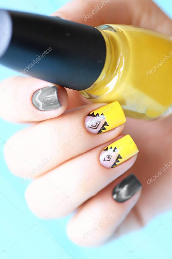 Bright woman manicure in trendy grey and yellow colors.Vertical orientation.Creative nail design.
