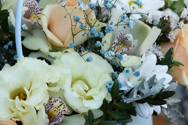 Close up photography of the bouquet from flowers.Composition from the different sorts: orchid,roses,eustoma.