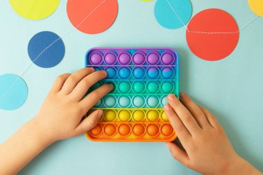 Gökkuşağıyla oynayan çocuk, yukarı bak. Çocuklar ve yetişkinler için yeni anti-stres oyuncağı..