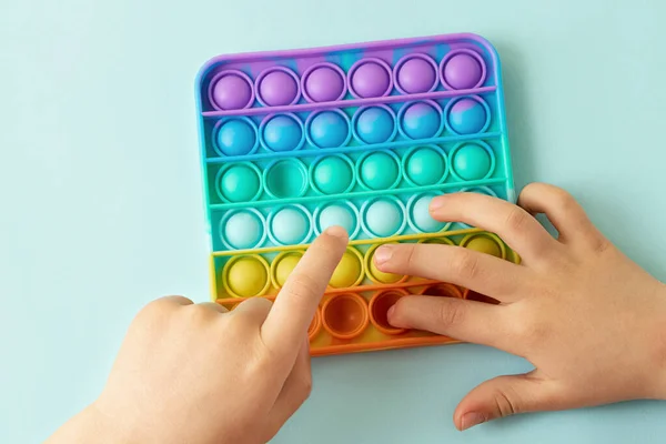 Child Playing Rainbow Pop Pressing Bubbles His Fingers Top View — Stock Photo, Image